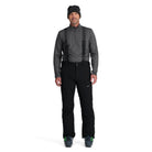 A man wearing a pair of black Spyder Men's Dare Ski Pants that are waterproof, insulated, breathable, and stretchable.