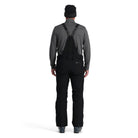 A man wearing a pair of black Spyder Men's Dare Ski Pants that are waterproof, insulated, breathable, and stretchable.