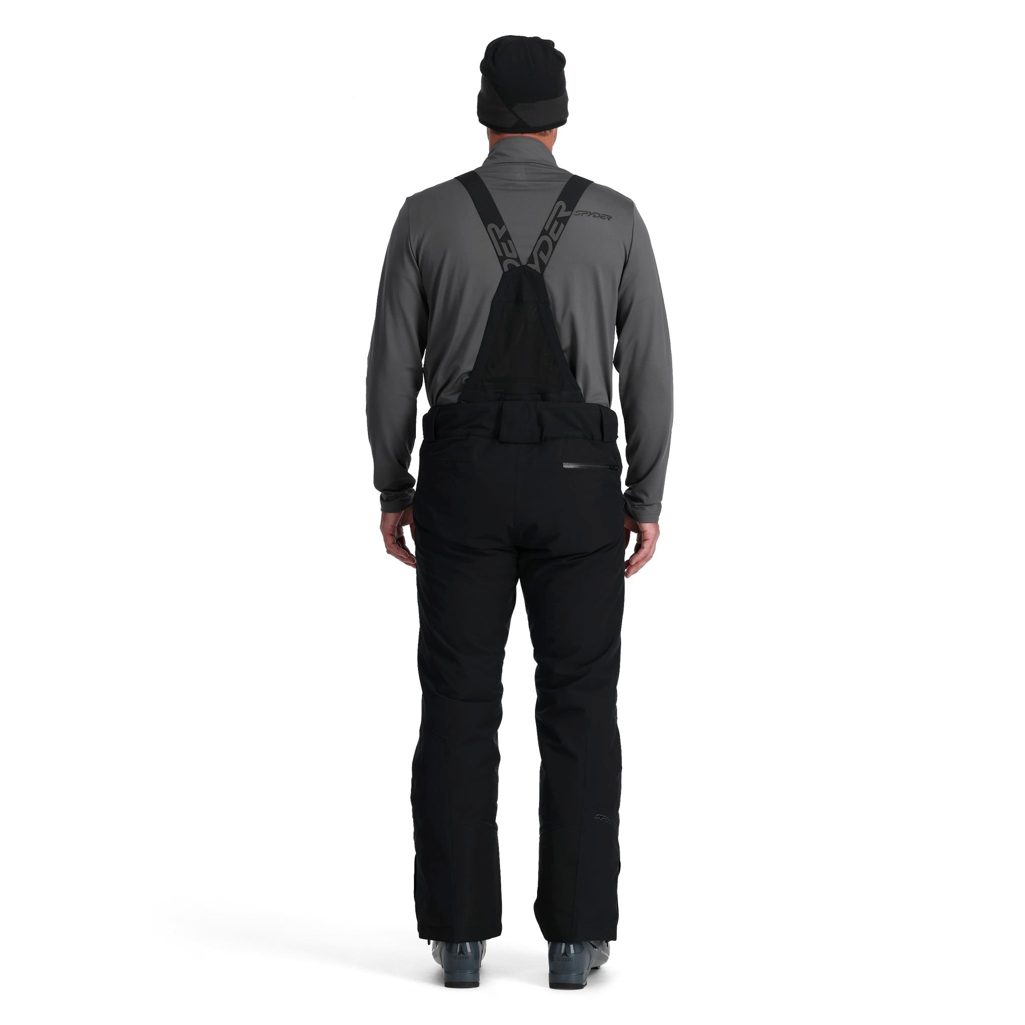 A man wearing a pair of black Spyder Men's Dare Ski Pants that are waterproof, insulated, breathable, and stretchable.