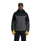 A man wearing a grey and black Spyder Men's Monterosa Ski Jacket that is waterproof, breathable, stretchable, and insulated.