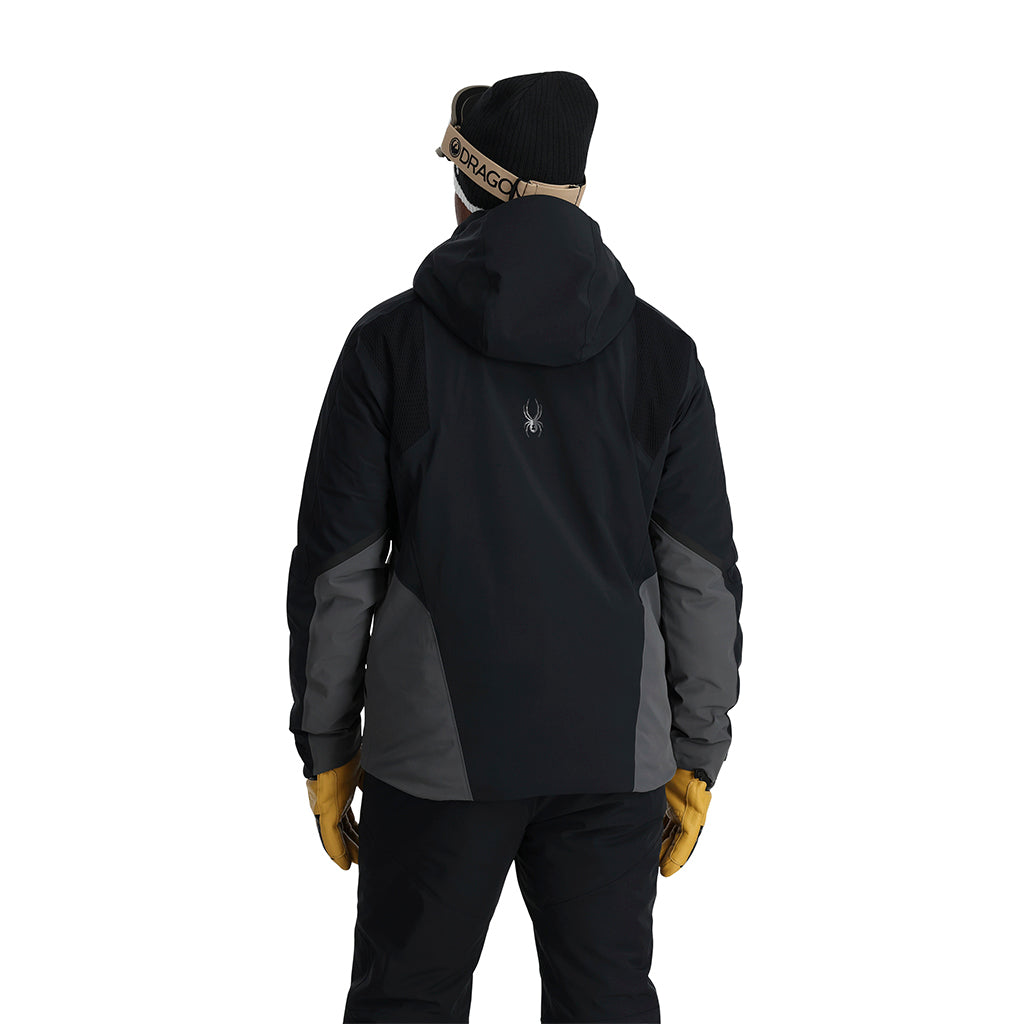 A man wearing a grey and black Spyder Men's Monterosa Ski Jacket that is waterproof, breathable, stretchable, and insulated.