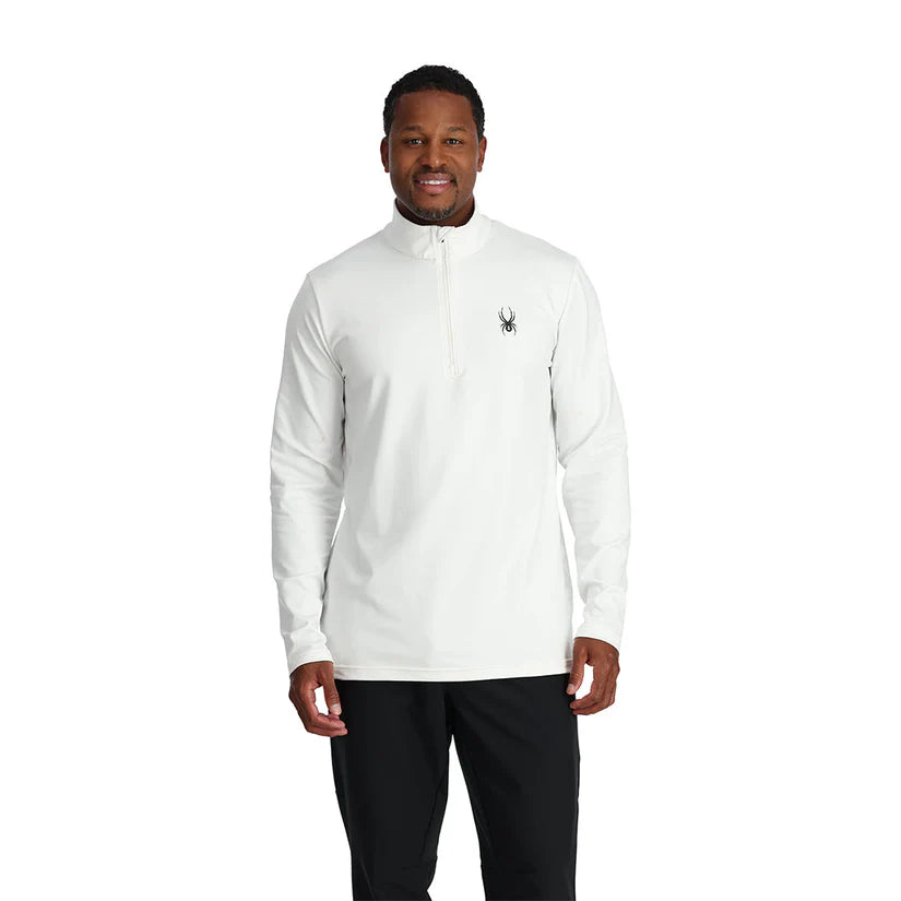 A man wearing a white Spyder Men's Prospect Turtleneck Midlayer Sweater that is breathable, stretchable, and moisture wicking.
