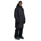 A man wearing a black Spyder Rain Shell Jacket that is waterproof and stretchable.