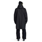 A man wearing a black Spyder Rain Shell Jacket that is waterproof and stretchable.