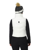 A woman wearing a white Spyder Women's Eastwood Down Vest that is waterproof, breathable, stretchable, and insulated with down.