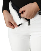 A close-up of a woman wearing a pair of white Spyder Women's On Piste Ski Bib Pants which are waterproof, breathable, stretchable, and insulated.