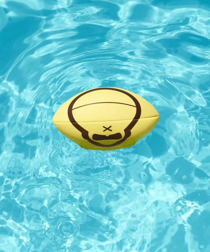 Yellow Sun Bum football with a Sun Bum logo floating on clear blue water