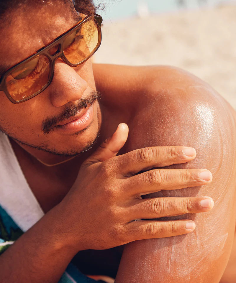 A man applying Sun Bum Original SPF 50 Sunscreen Lotion