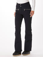 A woman wearing a pair of black Toni Sailer Women's Alla Ski Pants which are made from a premium technical fabric that is waterproof, breathable, stretchable, and insulated.