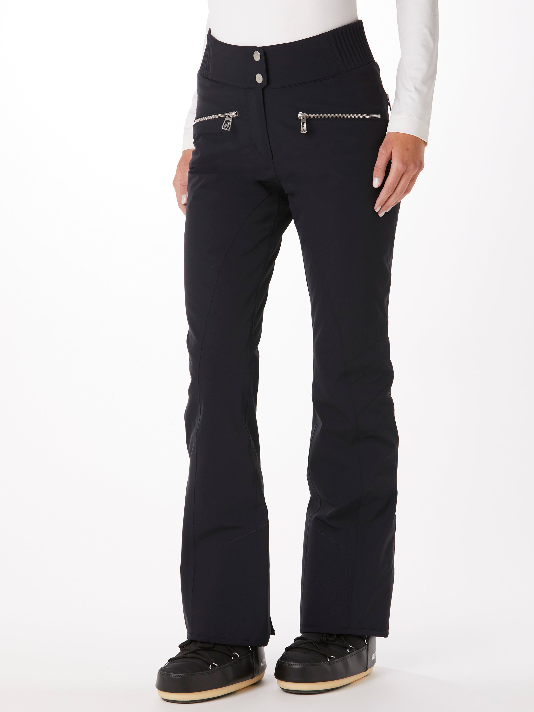 A woman wearing a pair of black Toni Sailer Women's Alla Ski Pants which are made from a premium technical fabric that is waterproof, breathable, stretchable, and insulated.