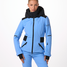 A woman wearing a blue and black Toni Sailer Women's Martha Ski Jacket that is made from premium fabrics and insulation that is waterproof, breathable, stretchable, and insulated.