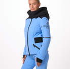 A woman wearing a blue and black Toni Sailer Women's Martha Ski Jacket that is made from premium fabrics and insulation that is waterproof, breathable, stretchable, and insulated.
