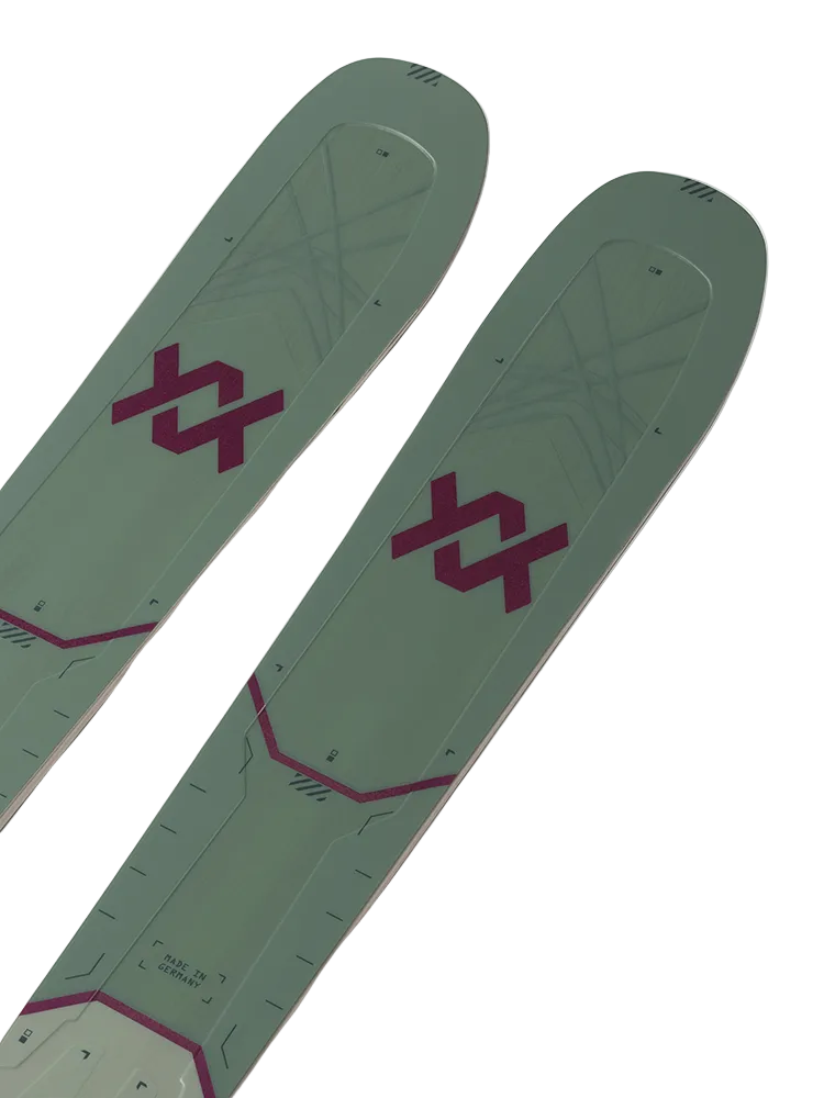 A pair of green and pink Volkl M7 Mantra W skis that are designed for all-mountain and freeride skiing, intended for expert female skiers.